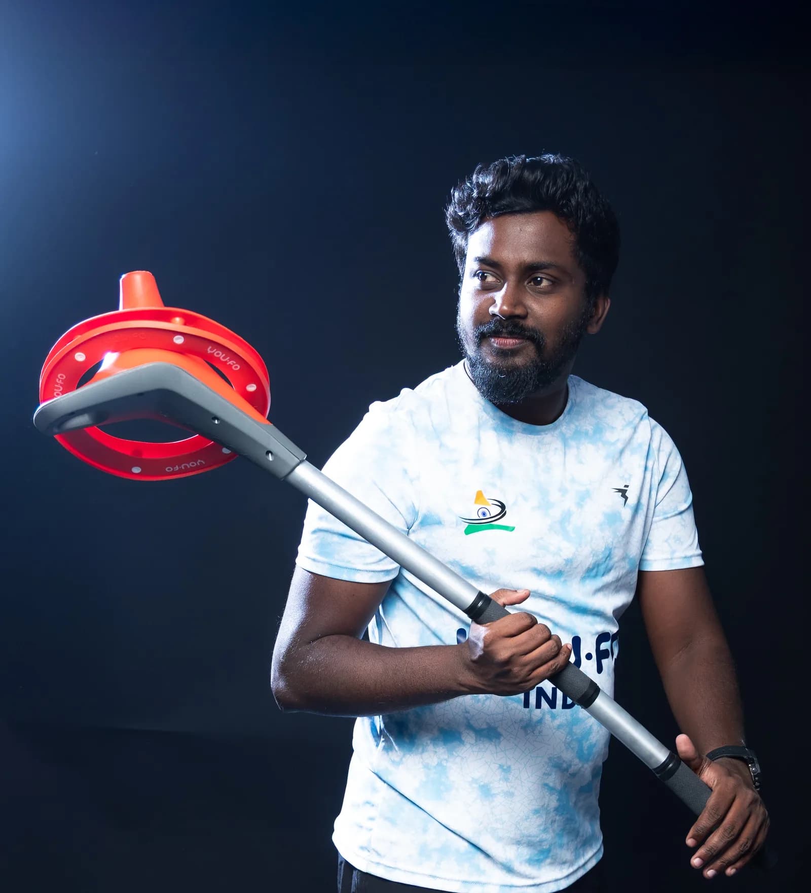 A YOU.FO India player holding the stick with the ring resting on the cone